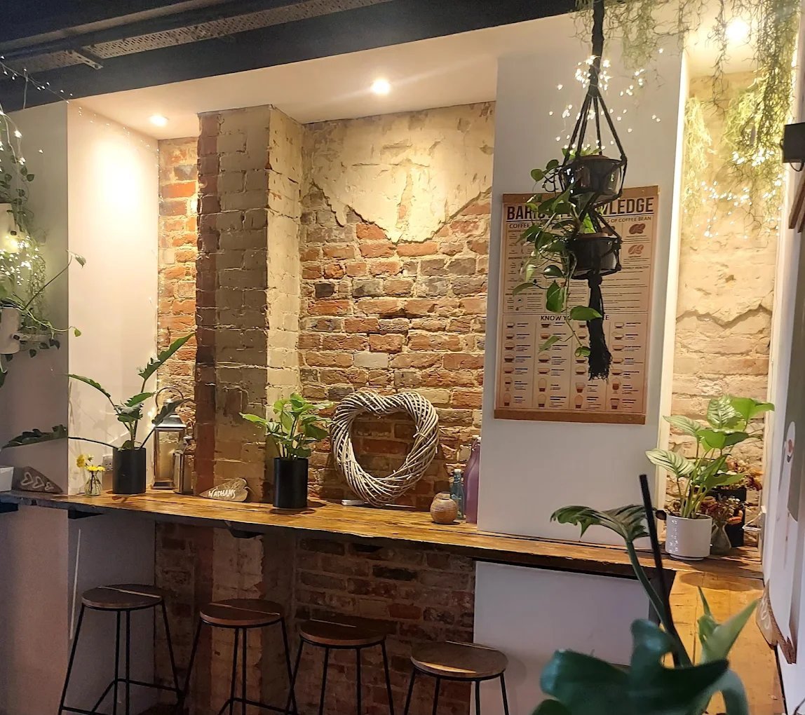Wadhams cafe counter with exposed brick walls, wooden bar top, bar stools, potted plants and decorative rope coil